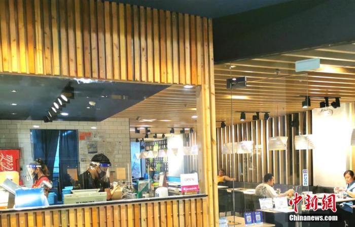 資料圖：6月26日，菲律賓首都馬尼拉餐飲業(yè)堂食“新常態(tài)”恢復(fù)。位于馬尼拉CBD馬卡蒂綠帶商圈餐廳，工作人員戴著口罩和面罩提供服務(wù)。<a target='_blank' >中新社</a>記者 關(guān)向東 攝